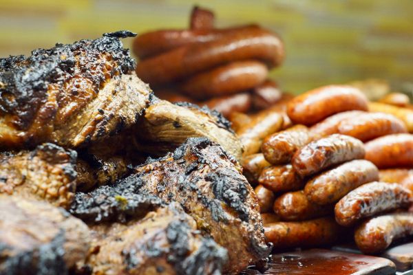 Grilled beef brisket and sausages on a BBQ.
